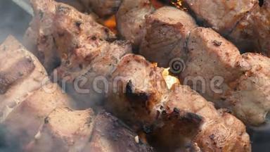 在金属扦子上烤什串。 厨师用手煮烤肉烧烤，烧烤时有很多烟。 烧烤新鲜牛肉排